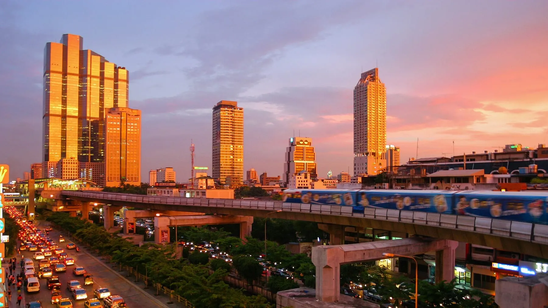 The bare rooftop under an open sky, city all around, taken at the hour the light goes gold.