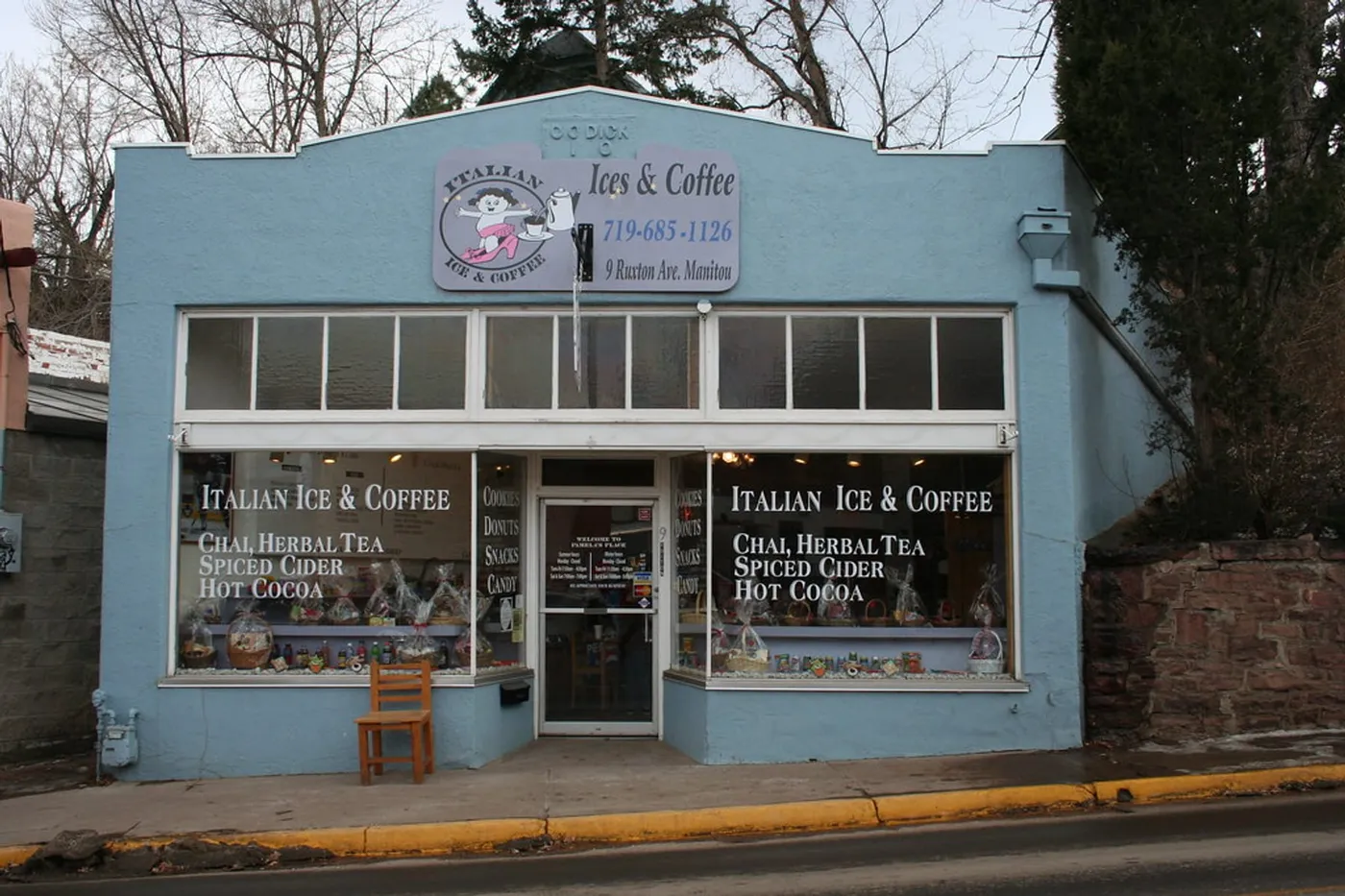The ground-floor shopfront from the pavement, door open, a barista visible behind the counter.