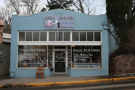 The ground-floor shopfront from the pavement, door open, a barista visible behind the counter.